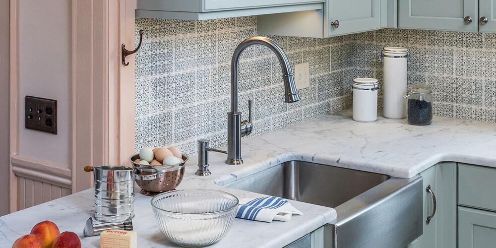Detailed tile pattern backsplash and updated countertops near kitchen sink