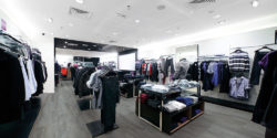 interior of retail shopping store with clothes and grey hardwood flooring