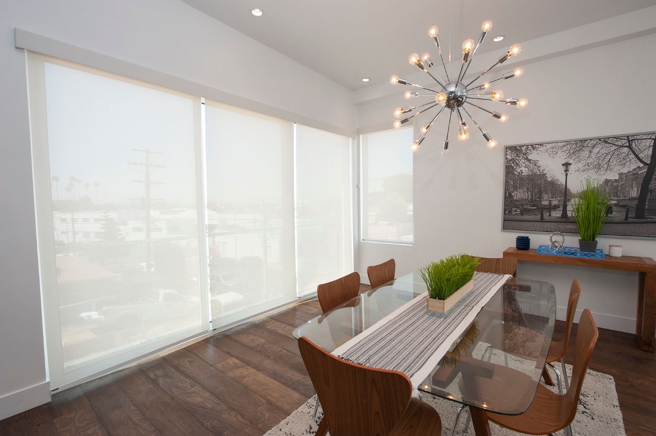 Dining room with roller shades on windows