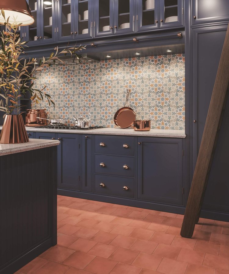 A bold backsplash design perfectly complements the warm terracotta square floor tiles.