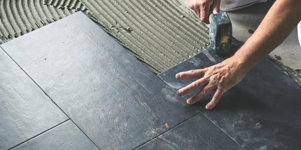 Worker placing waterproof floor tiles